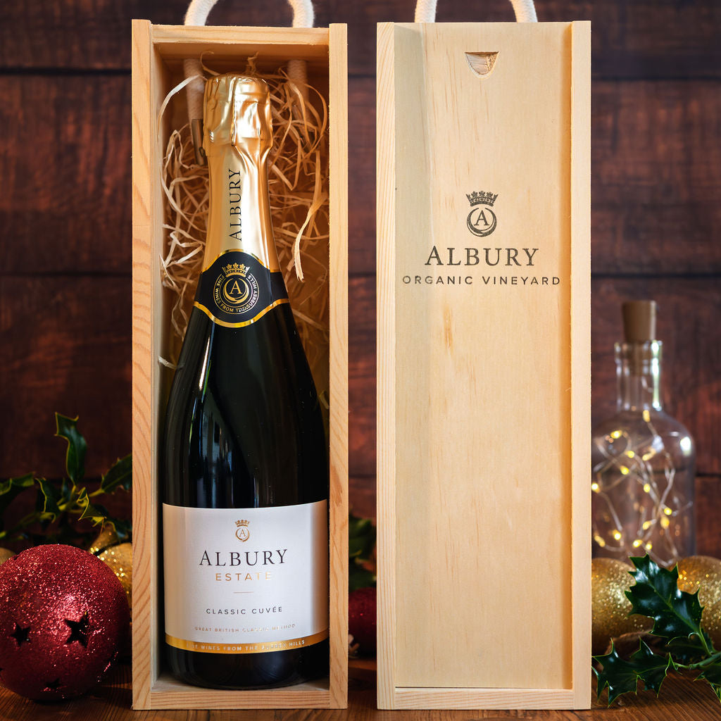 Albury wine bottle in a wooden box with festive decorations in the background
