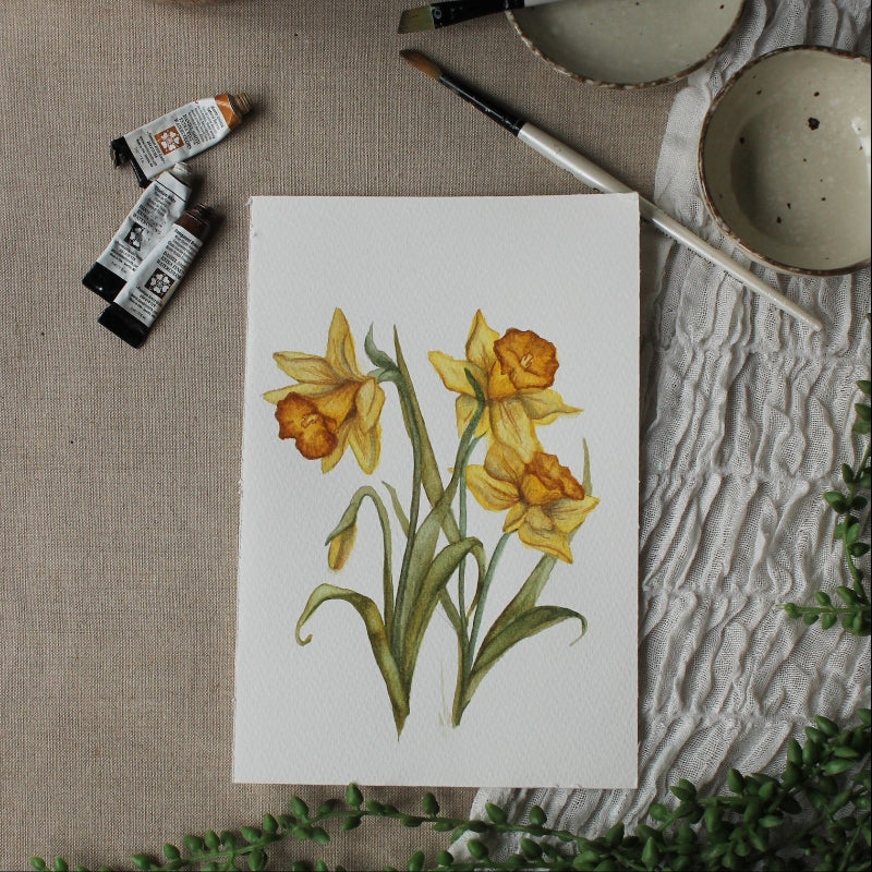 Artistic depiction of daffodils on a textured surface with painting supplies.